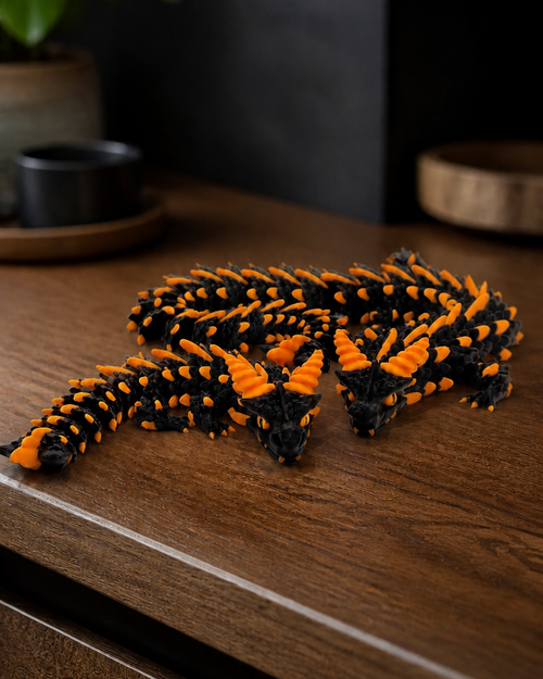 Emberling 3D-printet samledrage i Lava – svart/oransje, vist på en eikehylle. KI-generert miljøillustrasjon.